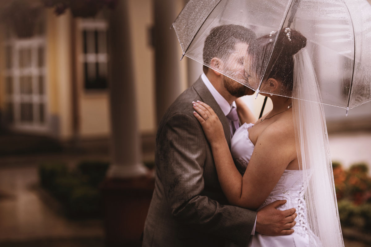 Nevěsta Martina v bílých šatech s ženichem pod deštníkem